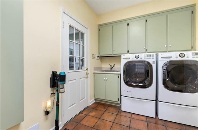 laundry room with dark tile patterned flooring, a sink, baseboards, cabinet space, and washing machine and clothes dryer