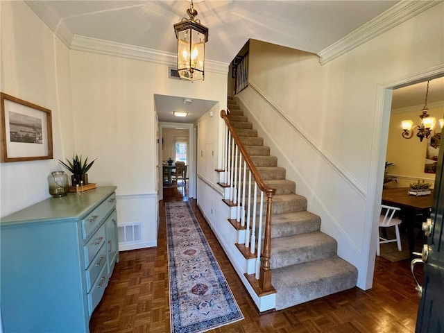 entryway with an inviting chandelier, stairs, visible vents, and ornamental molding