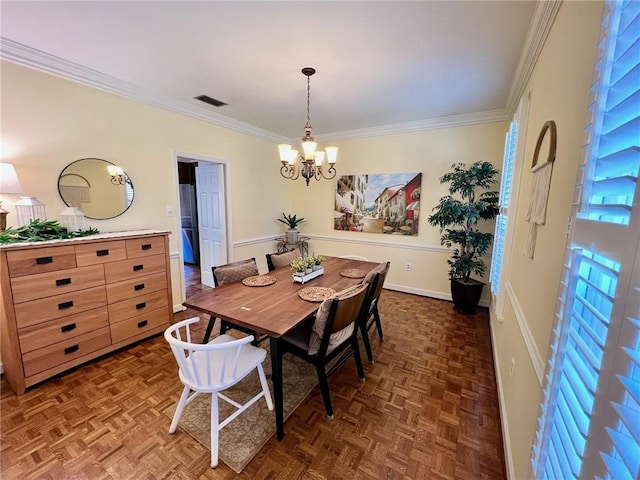 dining area with baseboards, ornamental molding, visible vents, and a notable chandelier