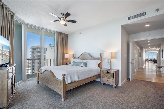 carpeted bedroom with access to exterior, multiple windows, and ceiling fan