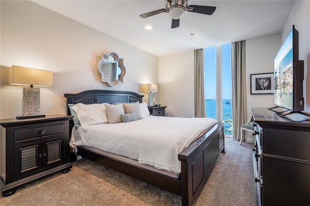 carpeted bedroom featuring a water view, ceiling fan, and access to outside