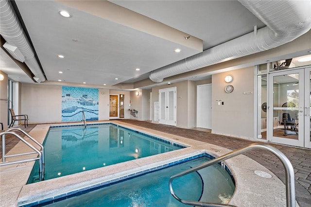 view of pool with french doors and an indoor in ground hot tub