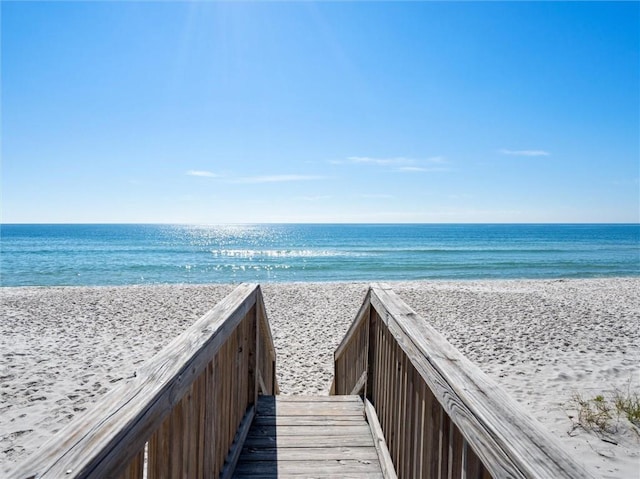 surrounding community with a water view and a view of the beach