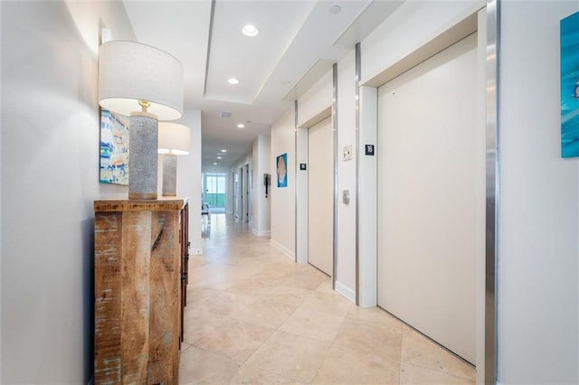hallway featuring light tile floors and elevator