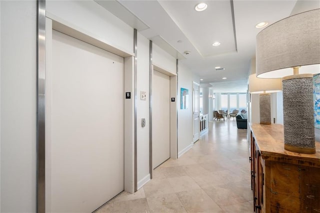 corridor featuring light tile flooring and elevator