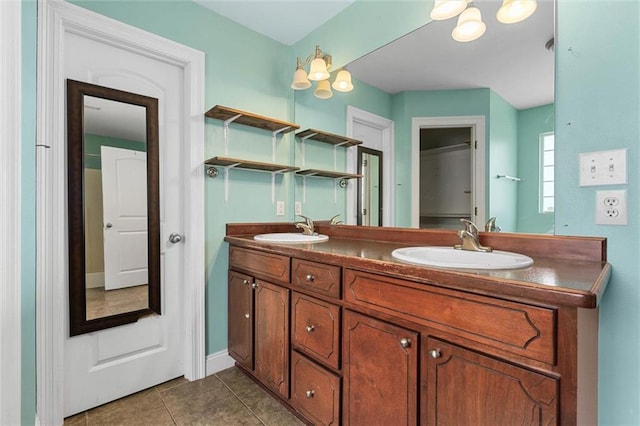 full bathroom featuring tile patterned flooring, a sink, baseboards, and double vanity