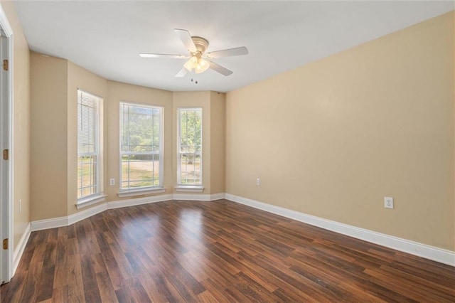 unfurnished room with baseboards, a ceiling fan, and dark wood-style flooring