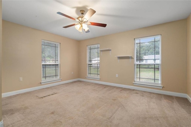 unfurnished room featuring baseboards, light carpet, and ceiling fan