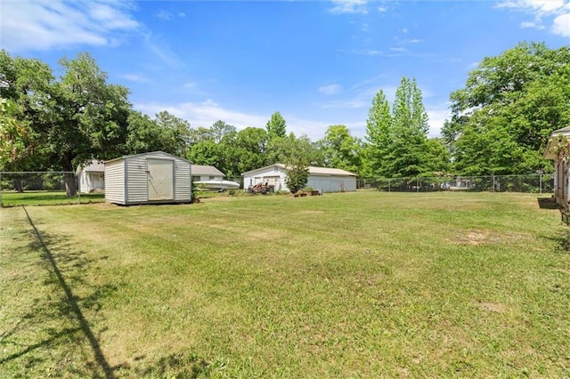 view of yard featuring a shed, an outbuilding, and fence