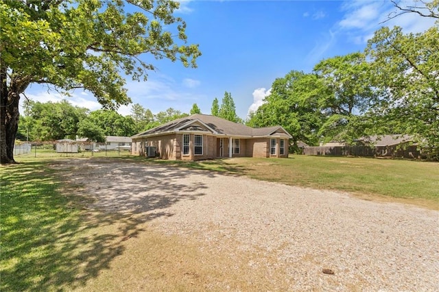 ranch-style house with fence, driveway, and a front lawn