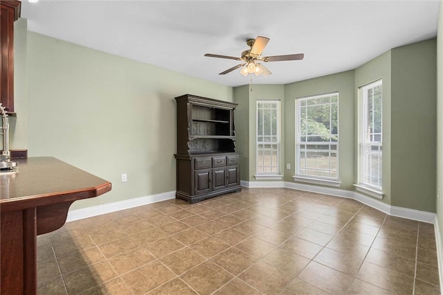 unfurnished living room featuring baseboards, ceiling fan, and tile patterned flooring