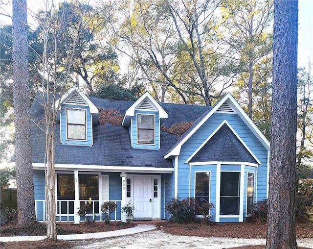 cape cod-style house with a porch and a shingled roof