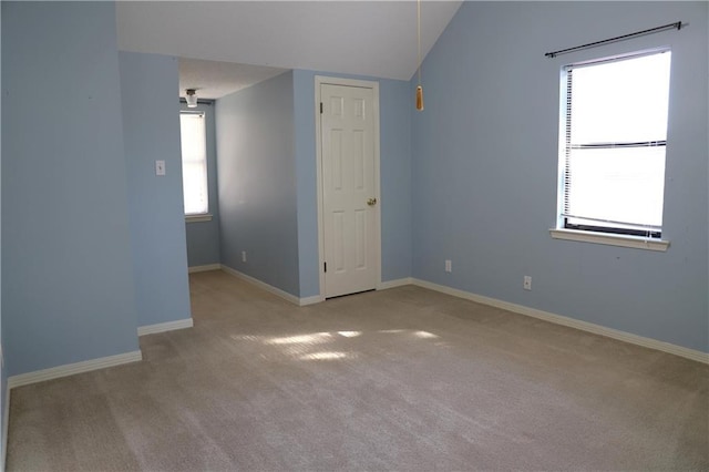 carpeted spare room with lofted ceiling