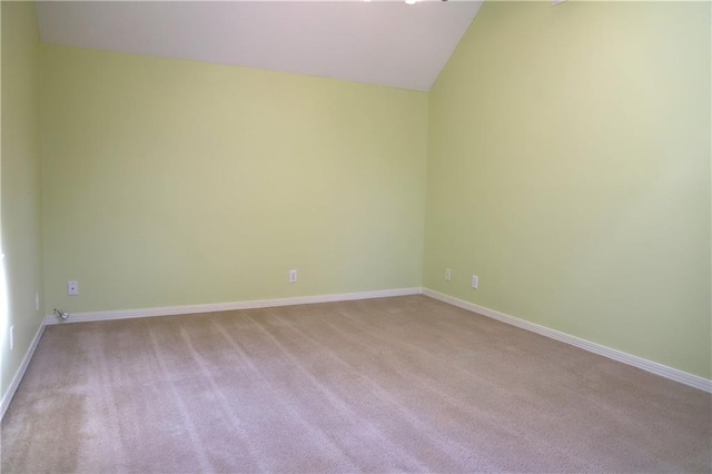 carpeted empty room with vaulted ceiling