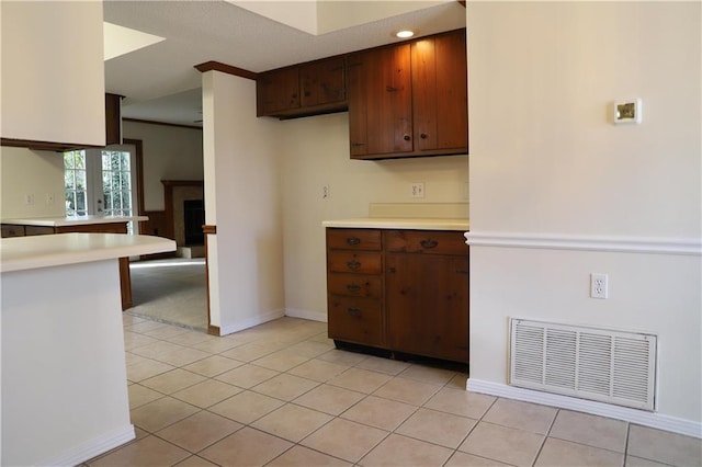 kitchen with light tile patterned flooring and dark brown cabinets