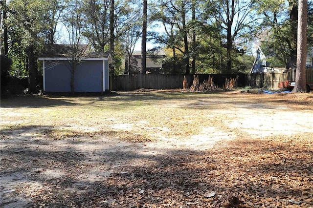 view of yard with fence, an outbuilding, and a storage unit