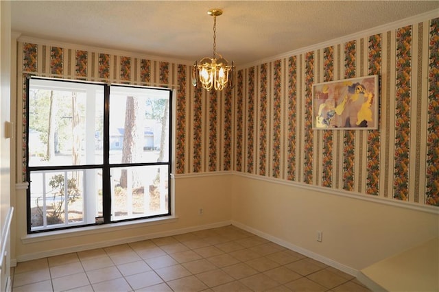 spare room with tile patterned flooring, crown molding, and a chandelier