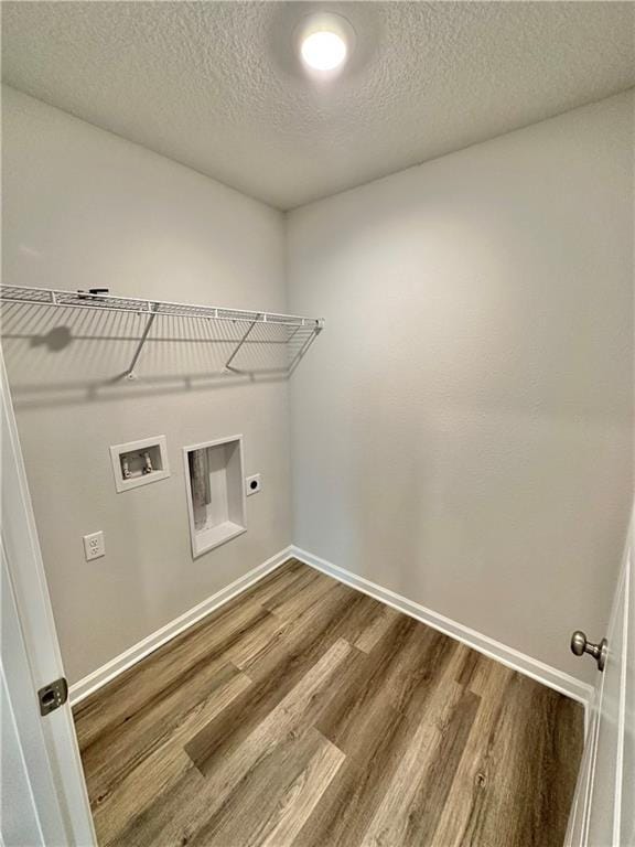 laundry area featuring electric dryer hookup, hardwood / wood-style floors, hookup for a washing machine, and a textured ceiling