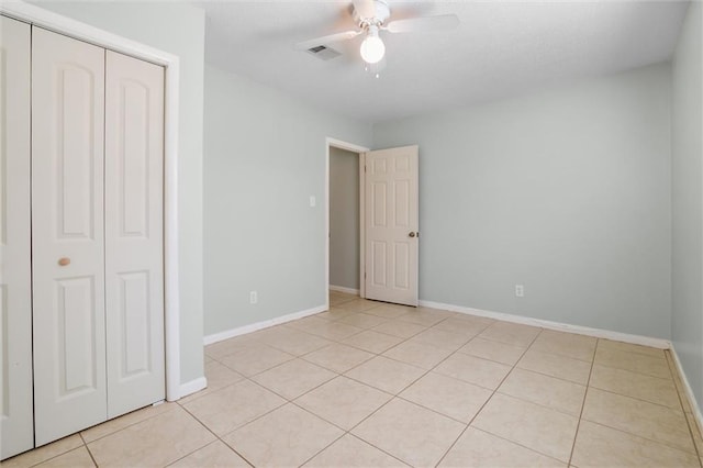 unfurnished bedroom with light tile patterned floors, baseboards, visible vents, ceiling fan, and a closet