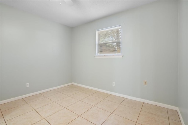 empty room featuring light tile patterned floors and baseboards