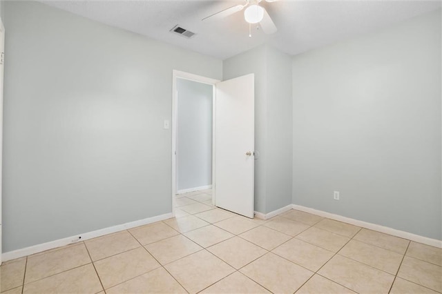 unfurnished room featuring a ceiling fan, visible vents, baseboards, and light tile patterned floors