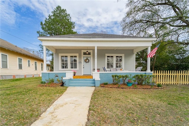 bungalow-style house with a porch, fence, and a front yard