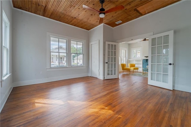 empty room with visible vents, wood finished floors, french doors, wood ceiling, and attic access