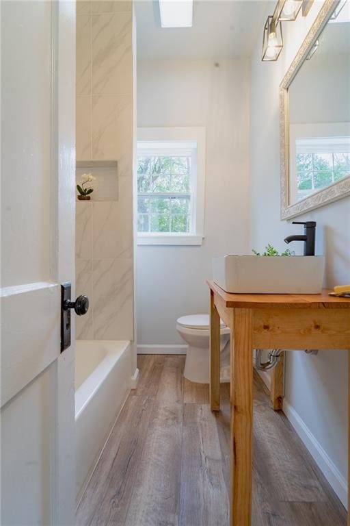 full bath with baseboards, toilet, wood finished floors, and vanity