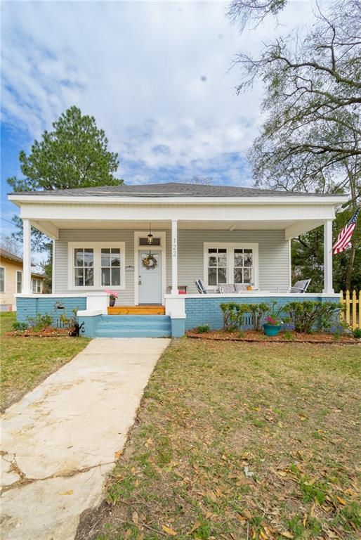 view of front of property with covered porch and a front yard