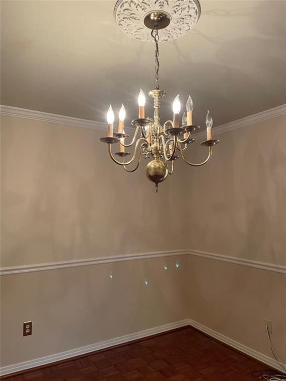 spare room with a notable chandelier and crown molding