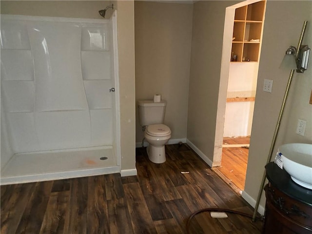 bathroom featuring a shower, vanity, wood-type flooring, and toilet