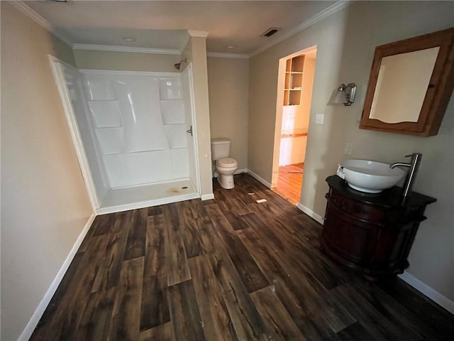 bathroom with walk in shower, ornamental molding, toilet, vanity, and hardwood / wood-style flooring