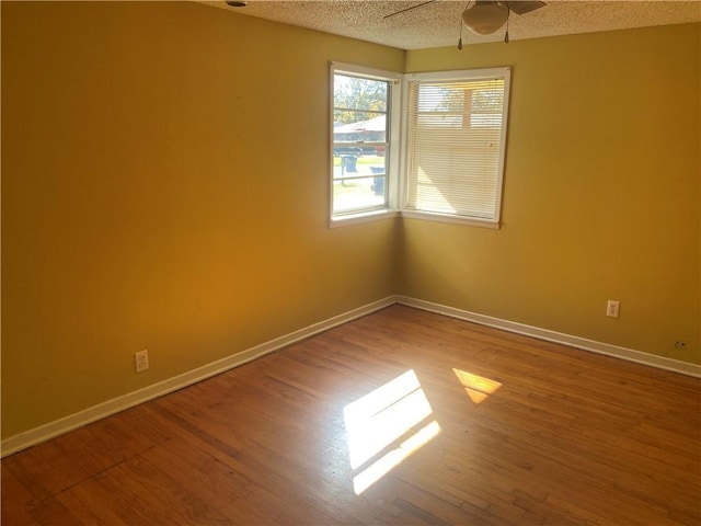 unfurnished room with wood-type flooring, a textured ceiling, and ceiling fan