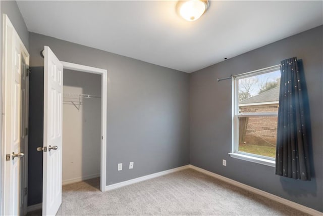 unfurnished bedroom featuring multiple windows, light carpet, and a closet