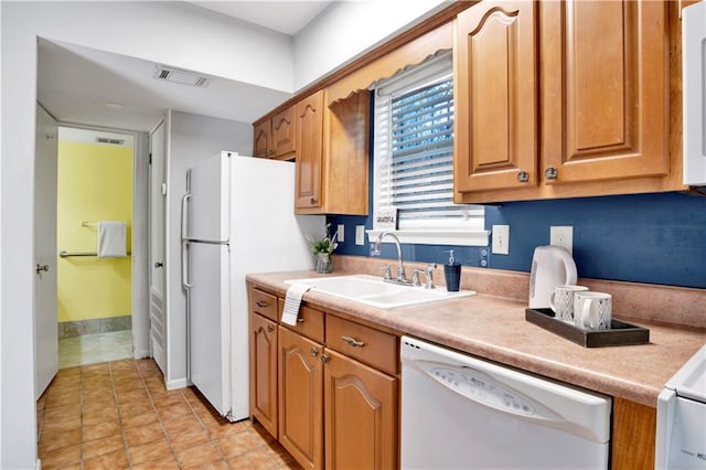 kitchen with light tile patterned flooring, white appliances, and sink