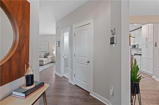 hallway featuring baseboards and wood finished floors