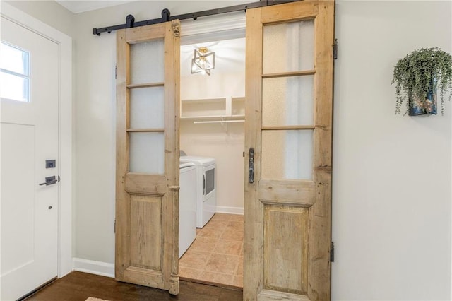 laundry area with a barn door and washing machine and dryer