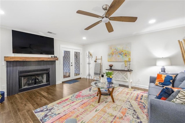 living room featuring dark hardwood / wood-style flooring, crown molding, french doors, and ceiling fan