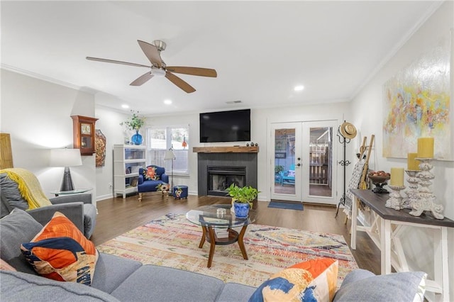 living room with crown molding, dark wood-type flooring, french doors, and ceiling fan