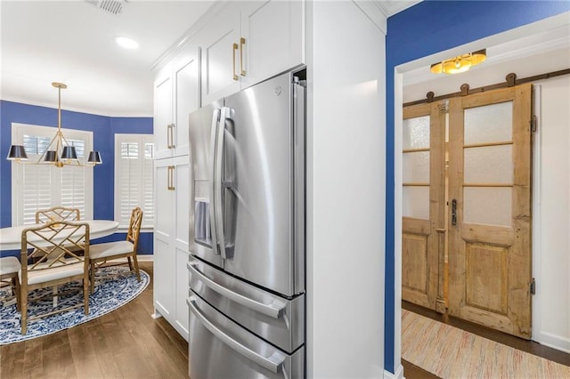 kitchen with pendant lighting, white cabinetry, stainless steel refrigerator with ice dispenser, a barn door, and dark wood-type flooring