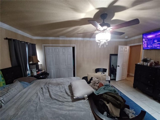 tiled bedroom with ceiling fan, a closet, and crown molding