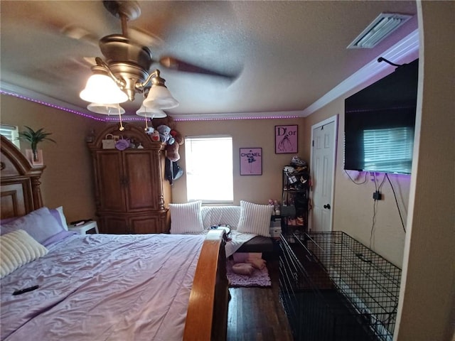 bedroom featuring ceiling fan, dark hardwood / wood-style floors, and a textured ceiling