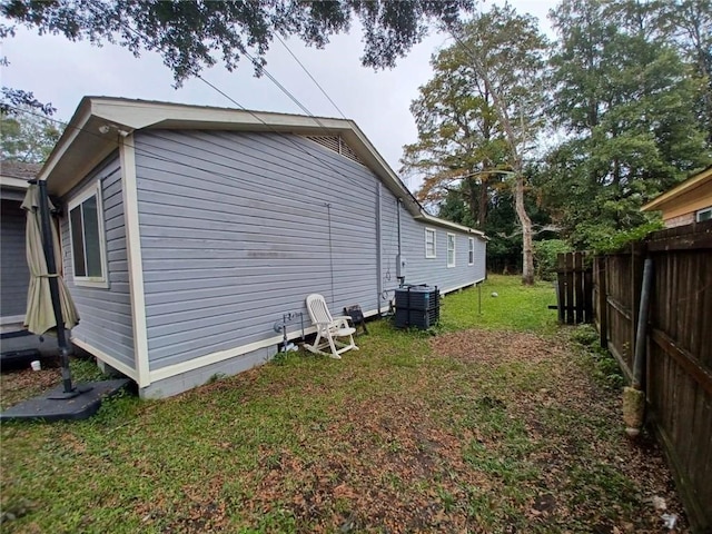 view of property exterior featuring central AC unit and a yard