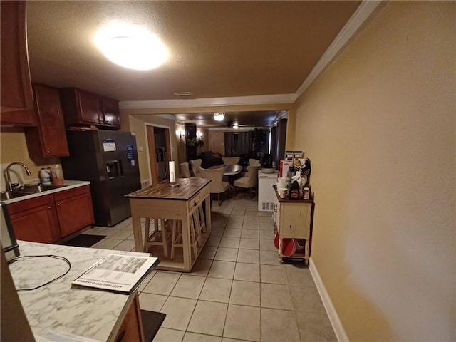 kitchen featuring light tile patterned flooring, black fridge, sink, and ornamental molding