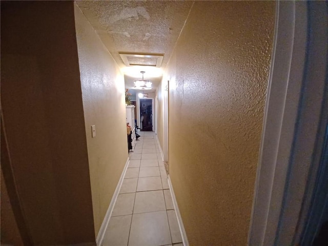 hallway featuring a textured ceiling and light tile patterned floors