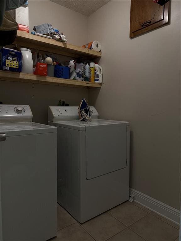 871 Briar Ct W, Mobile, AL 36609 - washroom featuring washing machine and clothes dryer, a textured ceiling, and light tile patterned flooring