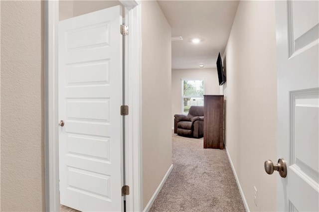 corridor with light carpet and baseboards