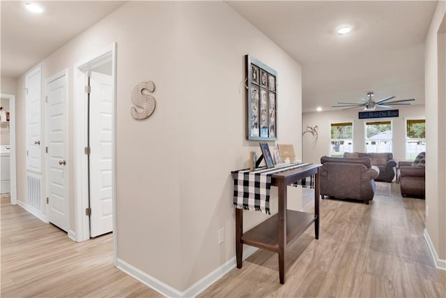 hall with light wood-type flooring, baseboards, and recessed lighting