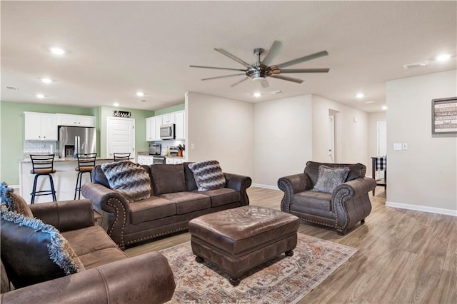 living area with light wood finished floors, baseboards, a ceiling fan, and recessed lighting