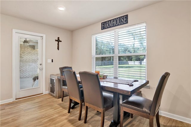 dining space featuring light wood-type flooring and baseboards